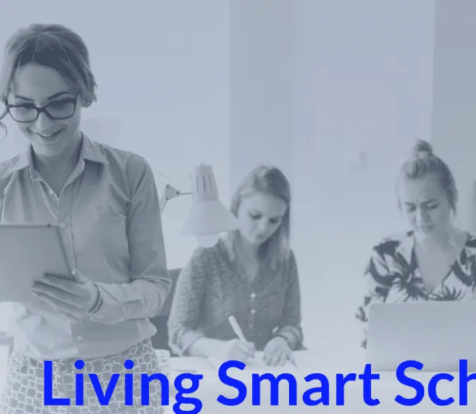 A faded, blue-tinted image of three women working in an office setting. In the foreground, a woman wearing glasses and a light-colored top is smiling while looking down at a tablet she is holding. Behind her, two other women are seated at a desk; one is writing, and the other is working on a laptop. The text 